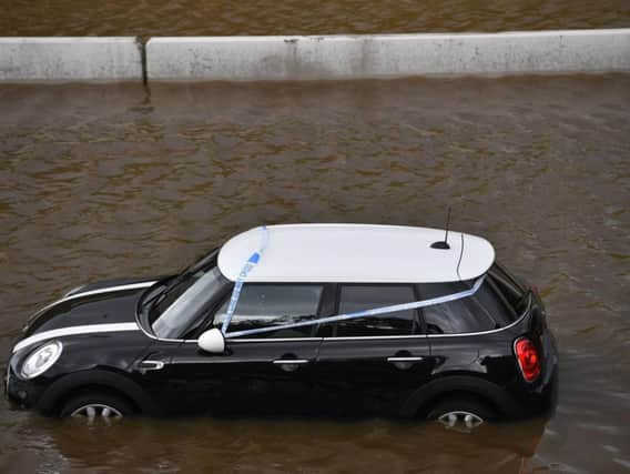 A car is stranded in flood waters in Greater Manchester