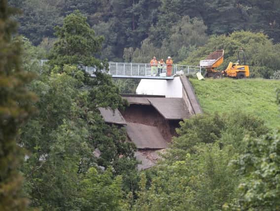 A team investigates the damage to the wall of the Toddbrook Reservoir near Whaley Bridge