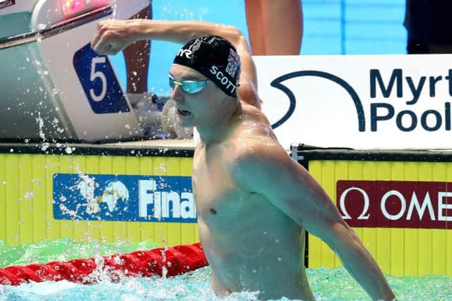 Duncan Scott slaps the water to celebrate medley relay gold. Picture: Catherine Ivill/Getty