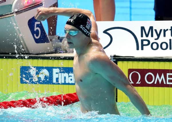 Duncan Scott slaps the water to celebrate medley relay gold. Picture: Catherine Ivill/Getty
