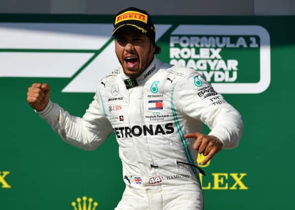Lewis Hamilton celebrates on the podium after winning the Hungarian Grand Prix on Sunday. Picture: Getty.