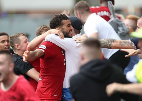 Connor Goldson is mobbed by fans after his late winner. Picture: Getty.