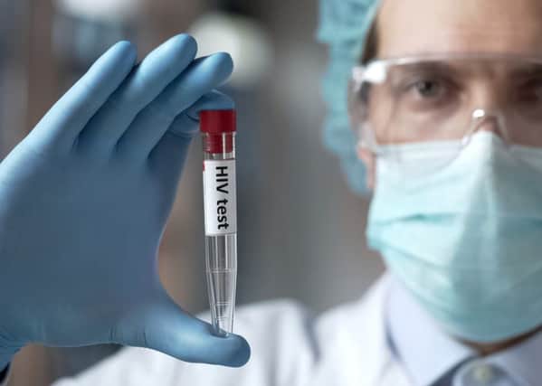 A laboratory expert holding a blood test for HIV antibodies