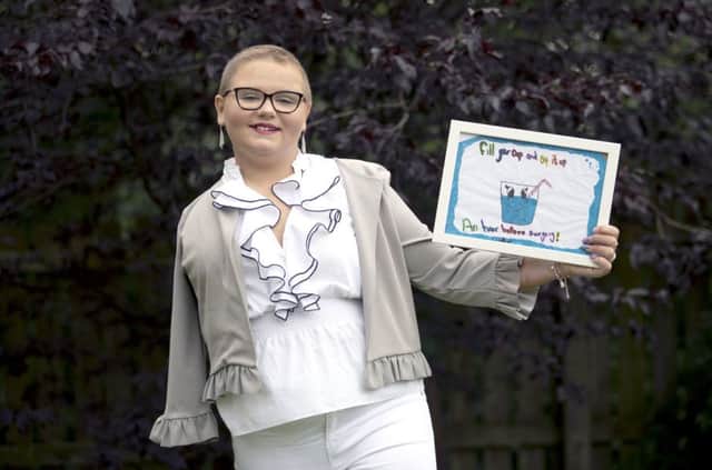 Skye Duncan, 14, from Gartloch, Glasgow, with a poster she designed using her left hand, which won a hospital art competition, shortly after her right arm was amputated following her battle with Osteosarcoma an aggressive form of bone cancer. Picture: Jane Barlow/PA Wire