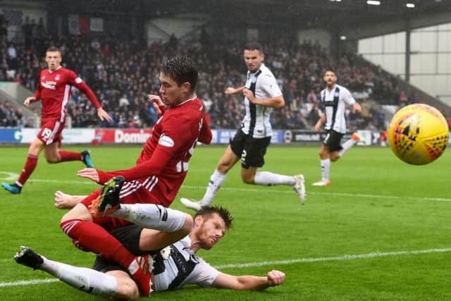 Aberdeen's Scott Wright is challenged by St Mirren's Gary MacKenzie at a wet Simple Digital Arena