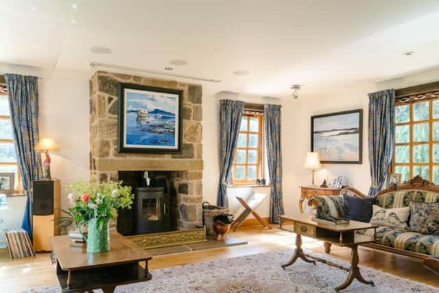 The cosy drawing room has exposed brick and a feature wood burning stove.