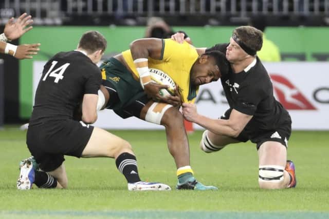 New Zealand's Scott Barrett, right, and Ben Smith combine to tackle Isi Naisarani of Australia. Picture: Trevor Collens/AP