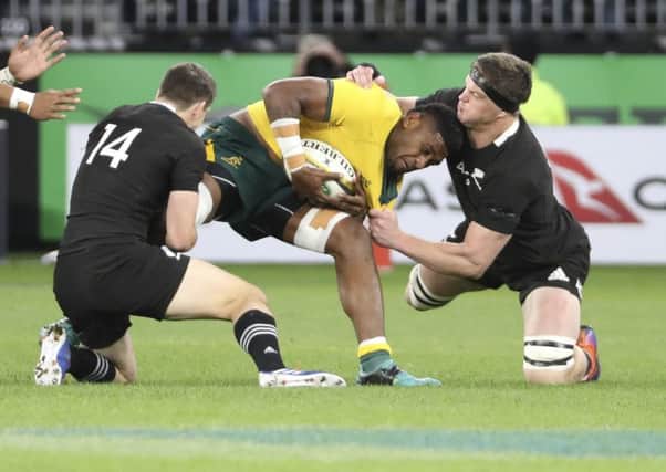 New Zealand's Scott Barrett, right, and Ben Smith combine to tackle Isi Naisarani of Australia. Picture: Trevor Collens/AP
