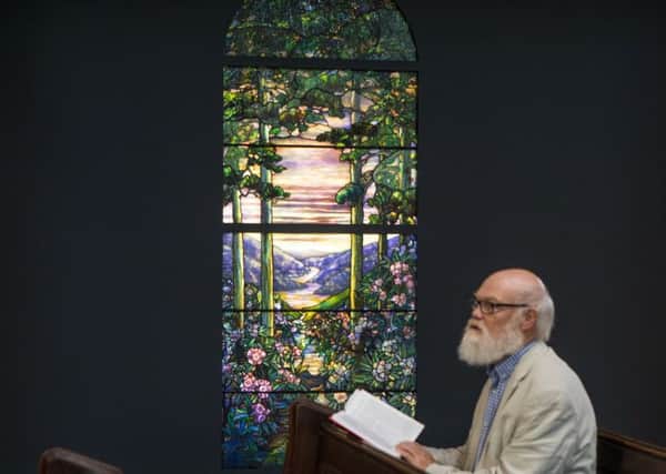 Christopher Gorman, a visitor to the abbey, reads nearby a window commissioned more than 100 years ago by the Scottish-American industrialist Andrew Carnegie
