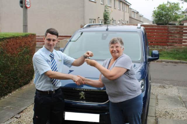 Assembler Scott Kane delivers a vehicle to Janet Grant and her husband Jim. Picture: contributed