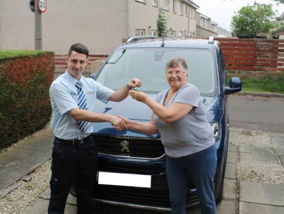 Assembler Scott Kane delivers a vehicle to Janet Grant and her husband Jim. Picture: contributed