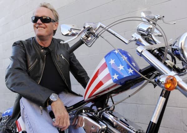 FILE - In this Friday, Oct. 23, 2009 file photo, Peter Fonda, poses atop a Harley-Davidson motorcycle in Glendale, Calif. Fonda, the son of a Hollywood legend who became a movie star in his own right both writing and starring in counterculture classics like "Easy Rider," has died. His family says in a statement that Fonda died Friday, Aug. 16, 2019, at his home in Los Angeles. He was 79. (AP Photo/Chris Pizzello, File)