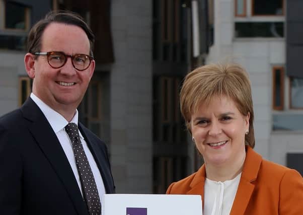 First Minister Nicola Sturgeon receives the Sustainable Growth Commission report from commission chair Andrew Wilson last year.