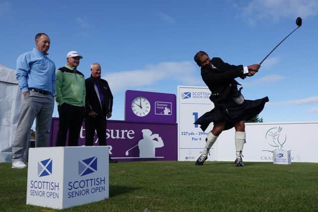 Donning the Black Watch tartan to embrace his Scottish roots, Kiwi Michael Campbell hits a ceremonial shot at Craigielaw ahead of the Scottish Senior Open watched by Gary Orr, Paul Lawrie and Sandy Lyle.