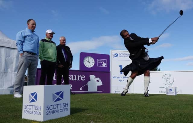 Donning the Black Watch tartan to embrace his Scottish roots, Kiwi Michael Campbell hits a ceremonial shot at Craigielaw ahead of the Scottish Senior Open watched by Gary Orr, Paul Lawrie and Sandy Lyle.