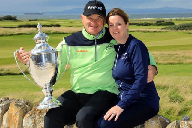 Paul Lawrie shows off the Scottish Senior Open trophy as he celebrates a two-shot win in the event at Craigielaw with his wife, Marian. Picture: Phil Inglis/Getty Images