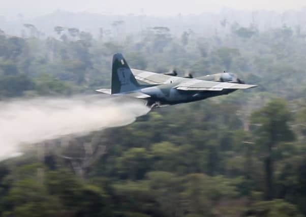 A C-130 Hercules aircraft dumps water to fight fires burning in the Amazon rainforest. Picture: AP