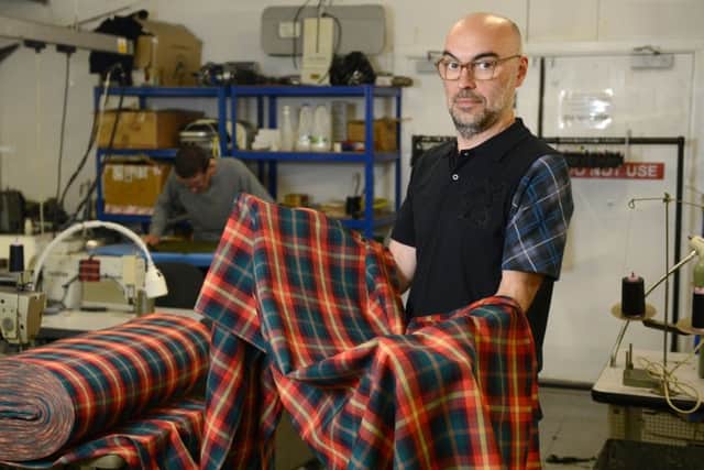 Marketing co-ordinator Calum Grant from Slanj Scotland with the first ever roll of Vegan tartan. Picture: SWNS