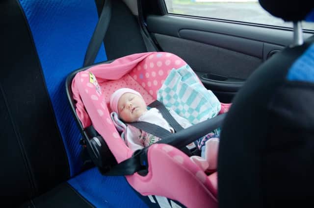 Newborn sleeping in car seat.