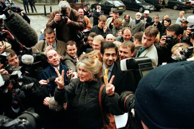 Brigitte Bardot flashes V for Victory signs outside the High Court in Edinburgh after Woofie the dog was saved