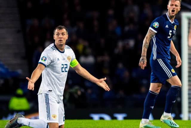 Artem Dzyuba alongside Scotland's Liam Cooper.