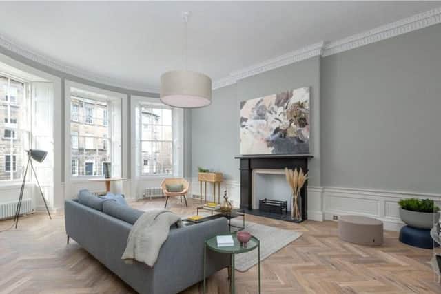 The spacious, light filled living room has a feature fireplace and parquet flooring.