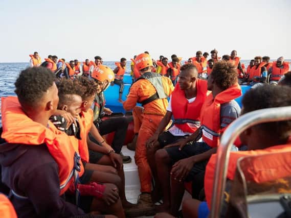 German migrant rescue charity NGO Sea-Eye helping people to get off an overloaded boat in July. Picture: Getty Images
