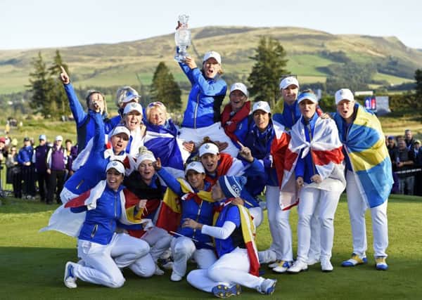 European captain Catriona Matthew holds the Solheim Cup aloft as she is lifted up by her team after their dramatic last-hole victory over Team USA at Gleneagles. Picture: Ian Rutherford/PA