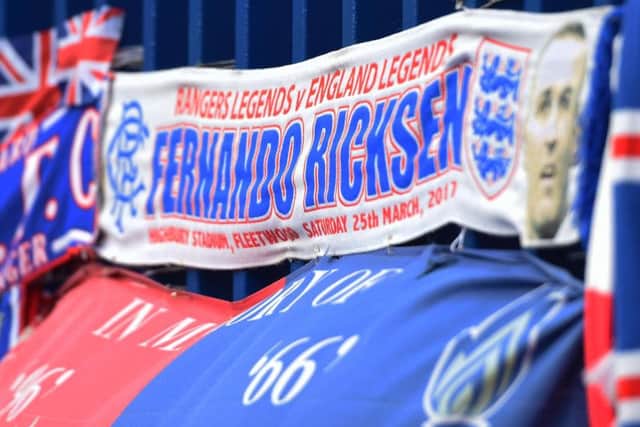 A scarf is displayed outside Ibrox as fans pay tribute to Fernando Ricksen