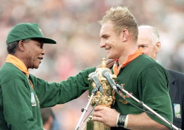 Nelson Mandela, wearing a Springboks shirt, presents the William Web Ellis trophy to Francois Pienaar (Picture: Dave Rogers/Allsport/Getty)