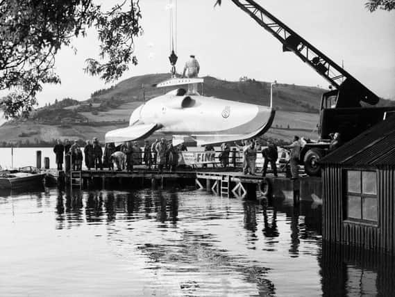 John Cobb watches his speedboat Crusader being lifted from Loch Ness in 1952. Cobb died the next day while attempting - and briefly accomplishing - the world water speed record.