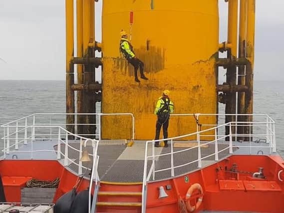 The Gus hoist system compensates for the action of the waves to safely transfer workers from boats on to offshore wind turbines