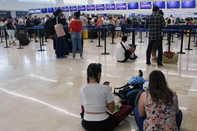 Passengers wait for news in Cancun airport.