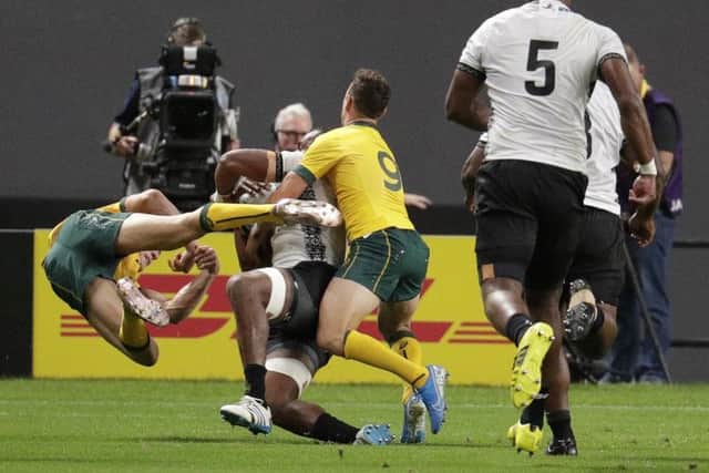 Australia's Reece Hodge, left, bounces back after his tackle on Fiji's Peceli Yato. Picture: Aaron Favila/AP