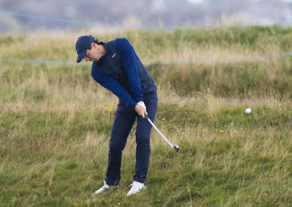 Rory McIlroy plays out of the rough at Carnoustie yesterday. Picture: Ross Parker/SNS