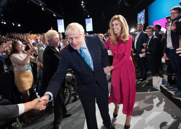 Boris Johnson, with girlfriend Carrie Symonds, is applauded after his speech to the Tory party conference (Picture: Stefan Rousseau/WPA Pool/Getty Images)