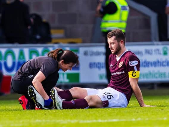 Craig Halkett receives medical attention before being substituted.