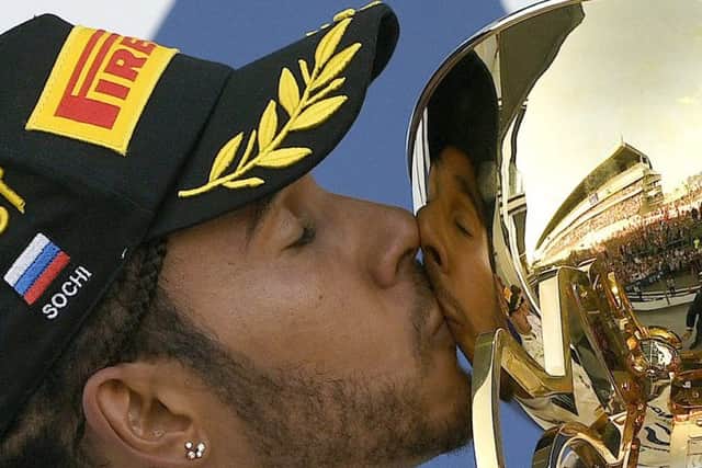 Lewis Hamilton celebrates with the trophy after his win in Russia.