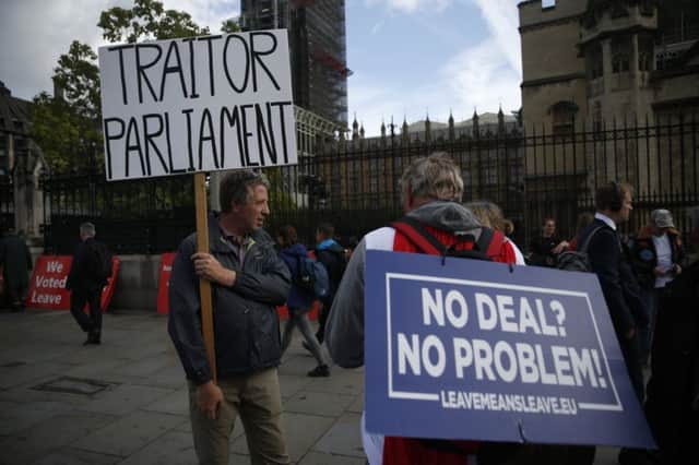 Brexit supporters hold placards outside the Houses of Parliament
