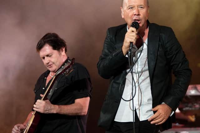Frontman Jim Kerr performs with guitarist Charlie Burchill