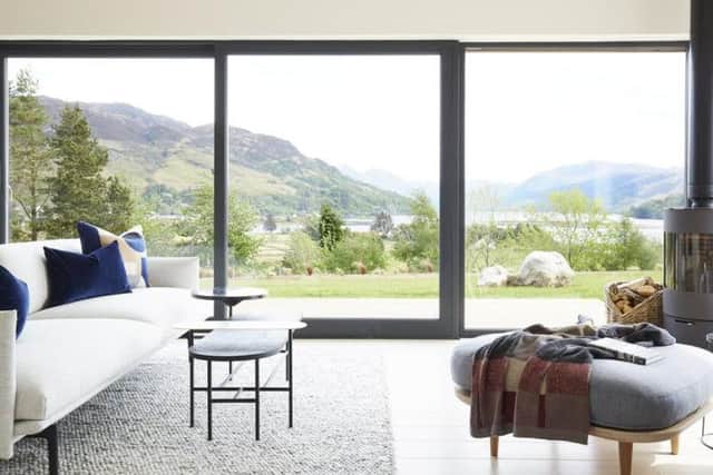 The cosy living room has floor to ceiling sliding doors that make the most of the cottage's location and views.