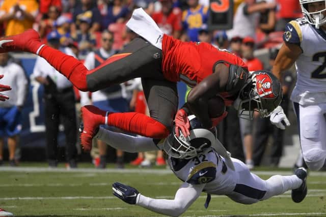 Tampa Bay Buccaneers wide receiver Chris Godwin, top, is tackled by LA Rams Eric Weddle. Picture: AP.