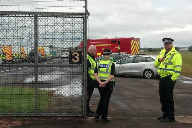 Police officers guard one of the entrances to the Glasgow Airport tarmac