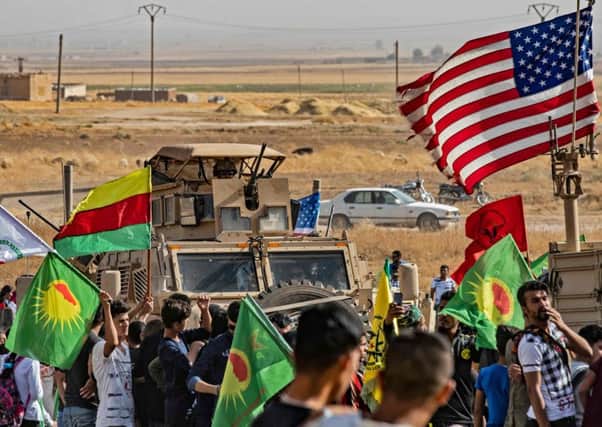 Syrian Kurds gather around a US armoured vehicle during a demonstration against Turkish threats. Picture: Delil Souleiman/AFP via Getty Images
