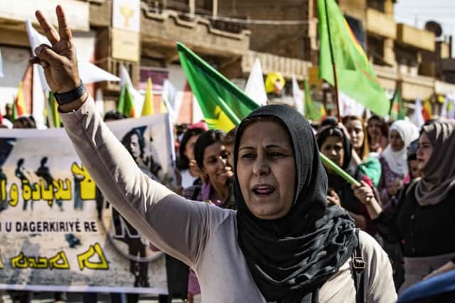 Syrian Kurdish women carry flags and banners as they demonstrate against Turkish threats to launch a military operation on their region. Picture: Delil Souleiman/AFP via Getty Images