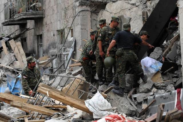 Georgian soldiers search for victims in destroyed buildings in Gori after shelling by Russia forces during the 2008 war. (Picture: Dimitar Dilkoff/AFP/Getty Images)