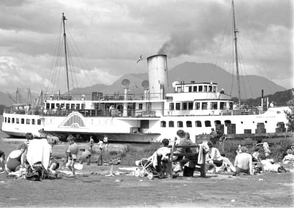 Holidaymakers enjoy the sun in Balloch as the Maid of the Loch paddle steamer passes by on Loch Lomond in July 1972
