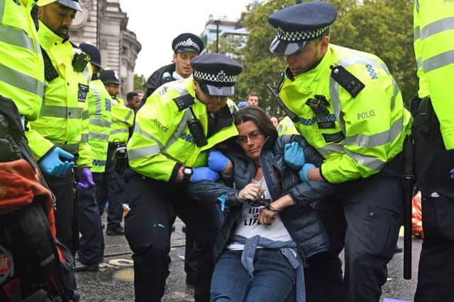 Protester being cut free, by police, from where they have chained and glued themselves on Victoria Street, outside Westminster Abbey. Picture: Victoria Jones/PA Wire