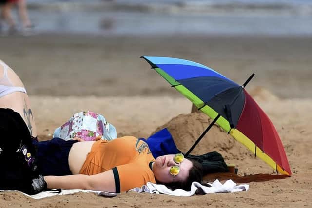 A beach goer catches some rays in Portobello this summer