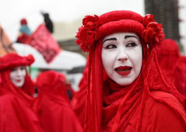 Climate change activists from the group Extinction Rebellion, dressed in red costume, demonstrate in London (Picture: Isabel Infantes/AFP/Getty Images)